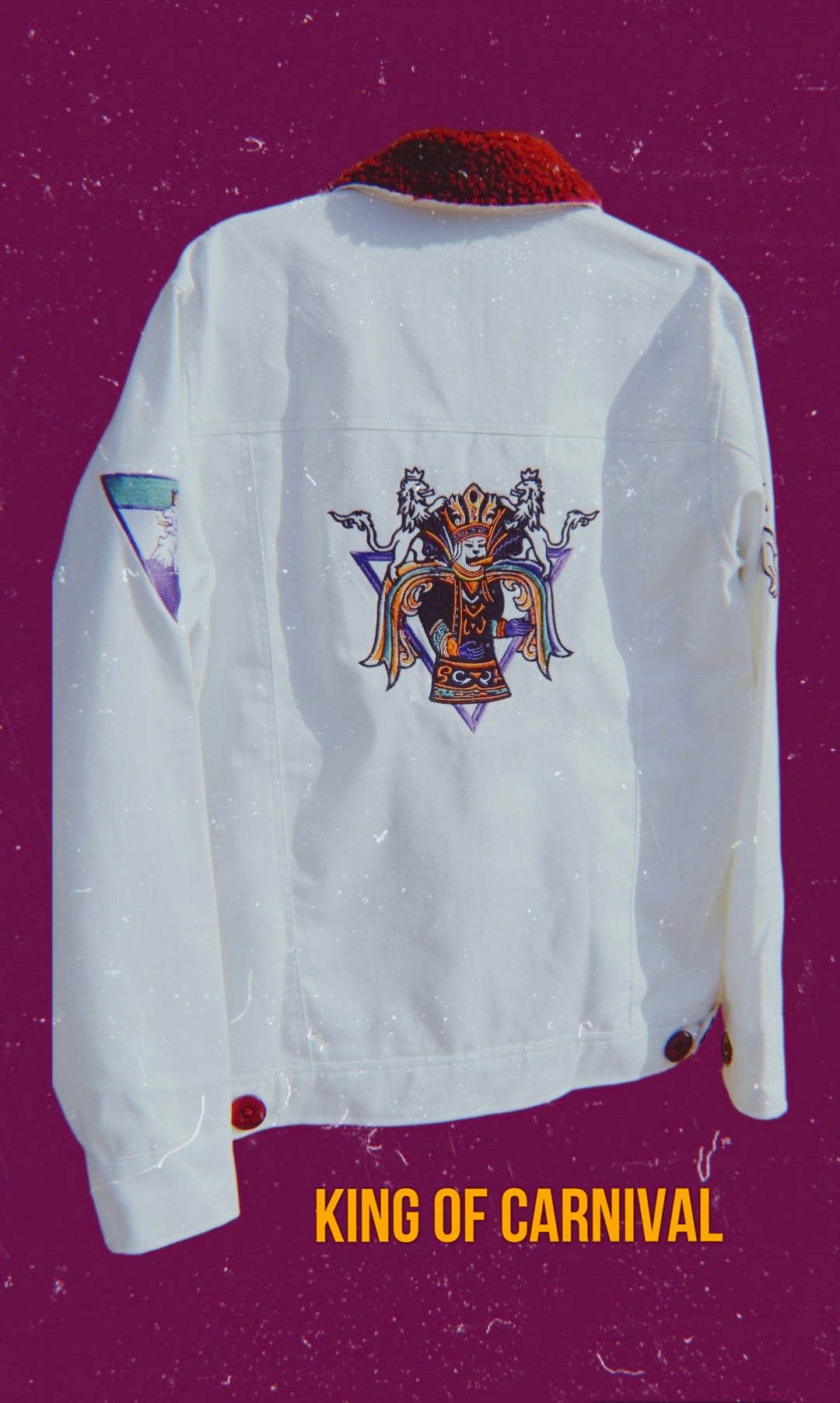 Marketing advertisement showcasing the Royalty10 Mardi Gras 24 King of Carnival Jean Jacket. This exquisite jacket features intricate embroidery, opulent purple fur collar, and stylish white denim fabric.
